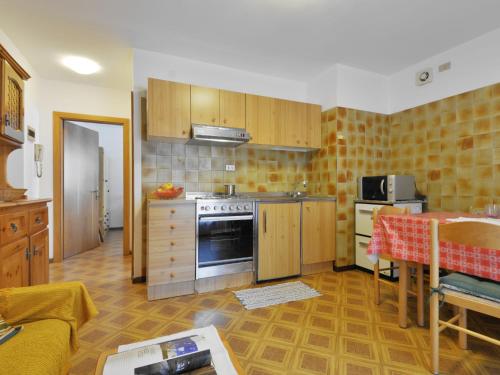 eine Küche mit Holzschränken und einem Herd mit Backofen in der Unterkunft Apartment Maura-2 by Interhome in Pozza di Fassa