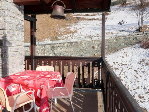 Ein Tisch und Stühle auf einem Balkon mit einem schneebedeckten Hang in der Unterkunft Apartment Coup d'Coeur by Interhome in Valtournenche