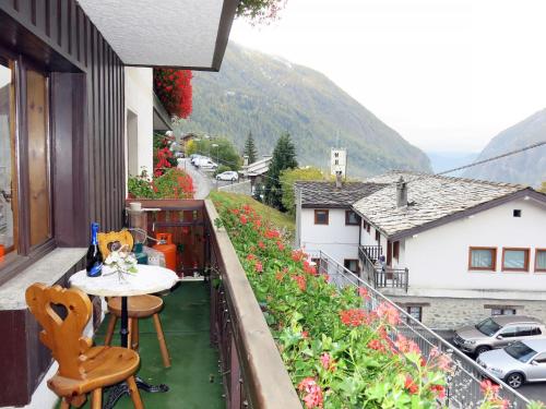 a balcony with a table and chairs and flowers at Apartment La Tata by Interhome in Valtournenche