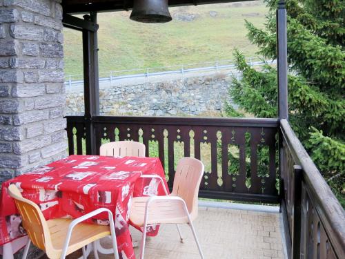 einen roten Tisch und Stühle auf einem Balkon mit einem Tisch und Stühlen in der Unterkunft Apartment Coup d'Coeur by Interhome in Valtournenche