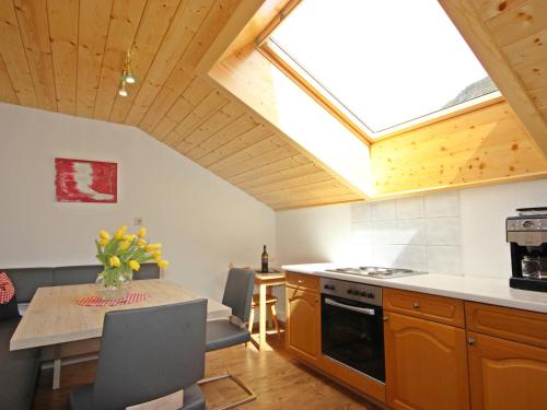 eine Küche mit einem Tisch und eine Küche mit einem Dachfenster in der Unterkunft Apartment Schmittnhof by Interhome in Niederthai