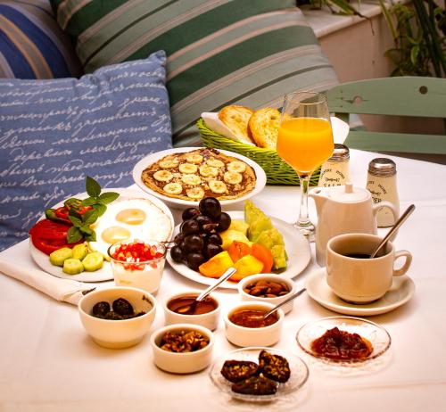 a table topped with plates of food and a glass of orange juice at Efchi 1904 in Rhodes Town