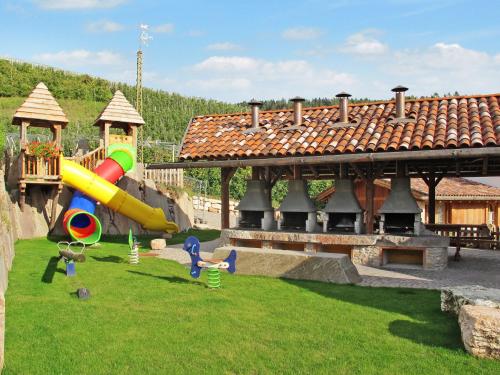 un parco giochi con scivolo sull'erba accanto a un edificio di Apartment Royal Gala by Interhome a Sanzeno