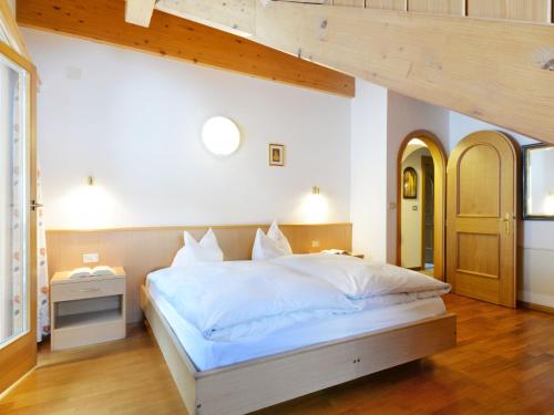 Schlafzimmer mit einem großen Bett mit einem Kopfteil aus Holz in der Unterkunft Apartment Ardoney-2 by Interhome in Campitello