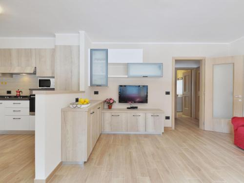 uma cozinha com armários brancos e uma televisão em Apartment Bernard-3 by Interhome em Campestrin