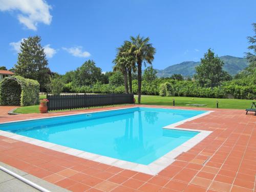 basen z ceglanym patio i palmami w obiekcie Holiday Home Teresa by Interhome w mieście Piaggiori