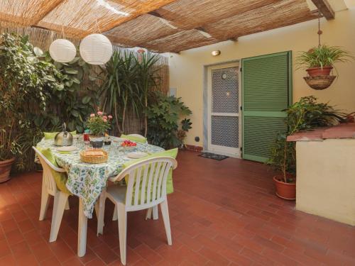 una sala da pranzo con tavolo, sedie e piante di Holiday Home Giuliana by Interhome a Massa