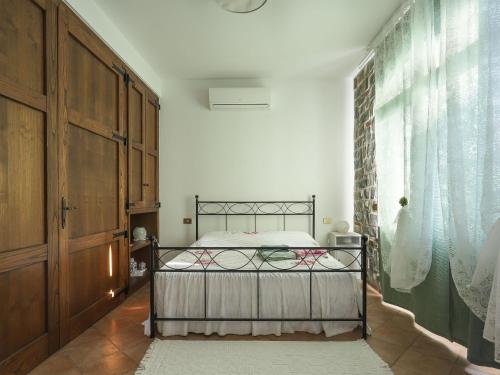 a bedroom with a bed and a large window at Apartment Carla - BLU150 by Interhome in Lugliano