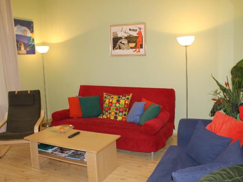 a living room with a red couch with colorful pillows at Apartment Chopina by Interhome in Sopot