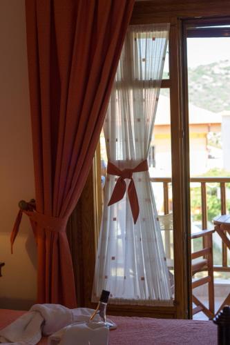 a white curtain with a bow on a window at Hotel Ismini in Ammouliani