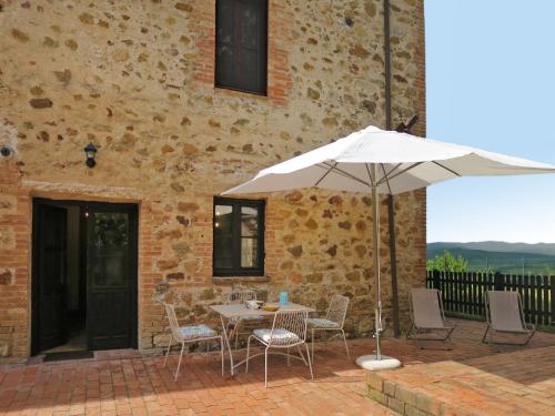 a table and chairs with an umbrella on a patio at Apartment Violapo al Castello by Interhome in Monte Antico