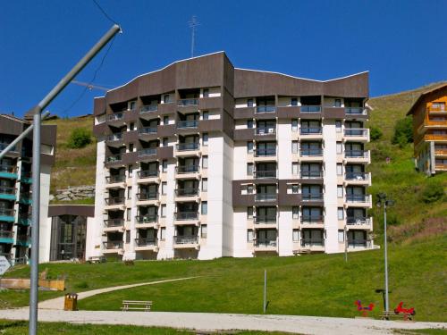 a large apartment building with a hill behind it at Apartment Armoise 73 by Interhome in Les Menuires