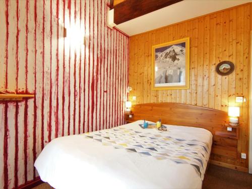 a bedroom with a bed with a red and white striped wall at Apartment Le Chailloud-2 by Interhome in Chamonix-Mont-Blanc