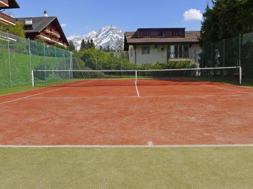 a tennis court in front of a house at Apartment Grand Hôtel A18 by Interhome in Villars-sur-Ollon