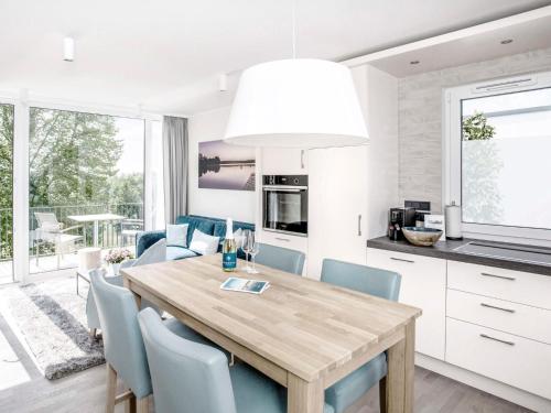 eine Küche und ein Esszimmer mit einem Holztisch und Stühlen in der Unterkunft Apartment Maremüritz-Aurora Müritzblick by Interhome in Waren (Müritz)