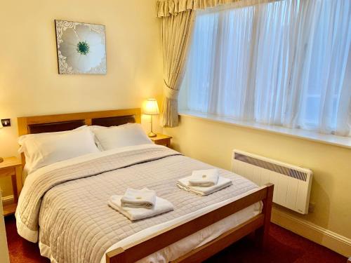 a bedroom with a large bed with towels on it at The Jolly Drover in Liss