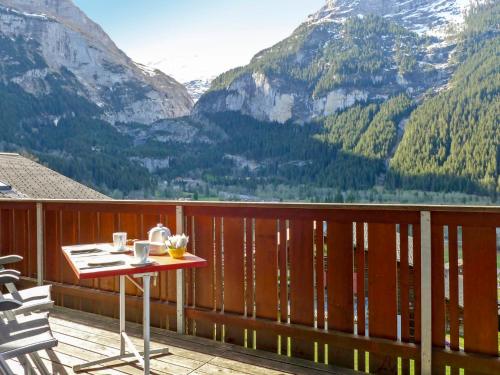 a table on a deck with a view of mountains at Holiday Home Chalet Ahornen by Interhome in Grindelwald