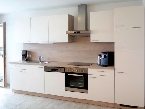 a kitchen with white cabinets and a stove top oven at Apartment Luxner - KAB137 by Interhome in Kaltenbach