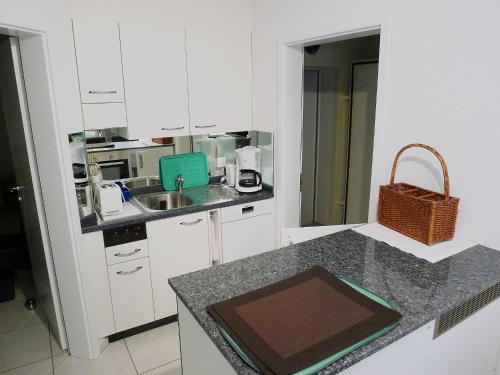 cocina con armarios blancos y encimera en Apartment Hegglistrasse 9-2 by Interhome, en Buochs