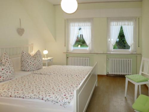 a bedroom with a white bed and two windows with christmas trees at Apartment Weingut Krempel by Interhome in Traben-Trarbach