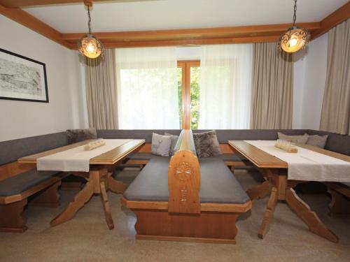 a dining room with two tables and a couch at Holiday Home Chalet Alpin by Interhome in Kaprun