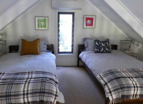 two beds in a room with a attic at Mansfield on the Manning in Tinonee