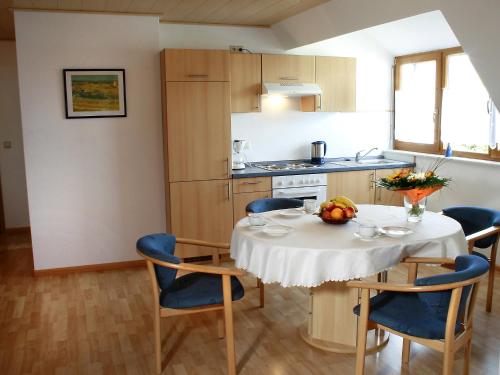 eine Küche mit einem Tisch und Stühlen sowie eine Küche mit einem Tisch und einem Stuhl in der Unterkunft Apartment Dieboldshof by Interhome in Neuried