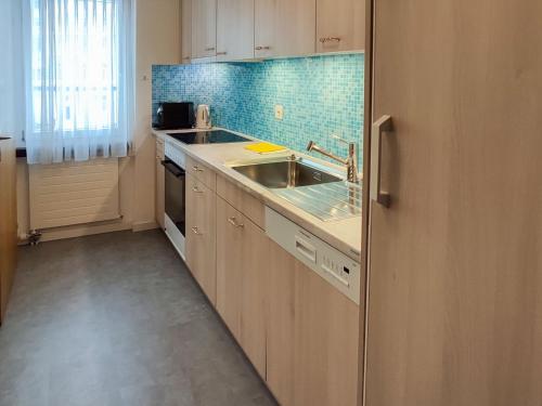 a small kitchen with a sink and a stove at Apartment Allod Park Haus C 505 by Interhome in Davos