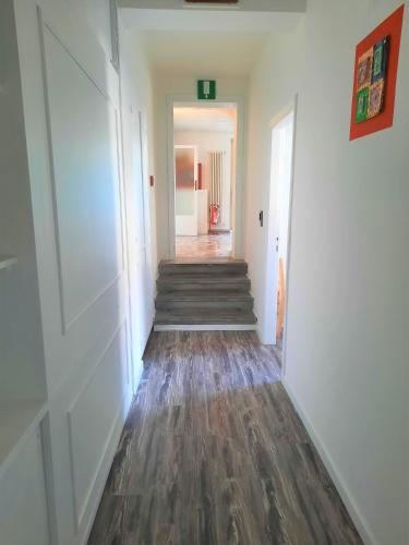 a hallway with white walls and wooden floors at Hotel San Francesco e il lupo in Gubbio