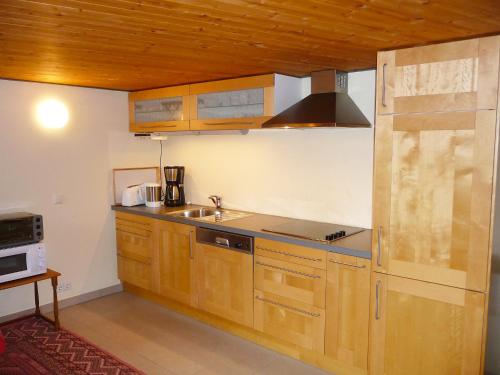 een keuken met houten kasten en een wastafel bij Apartment Haus Schanbacher by Interhome in Sterneck