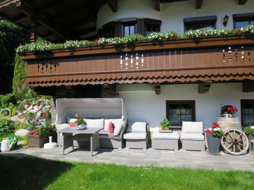 een patio met stoelen en een tafel en een gebouw bij Apartment Viktoria - ZAZ761 by Interhome in Aschau