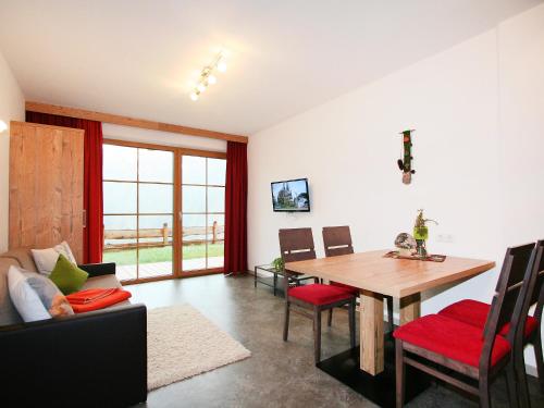 salon z drewnianym stołem i krzesłami w obiekcie Apartment s' HimmelReich-1 by Interhome w mieście Huben