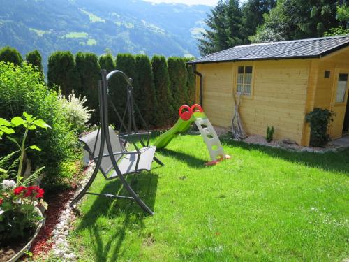 een tuin met een speeltuin met een glijbaan bij Apartment Viktoria - ZAZ761 by Interhome in Aschau