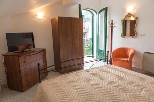 a bedroom with a bed and a dresser and a television at Rianna Rooms & Breakfast in Scala
