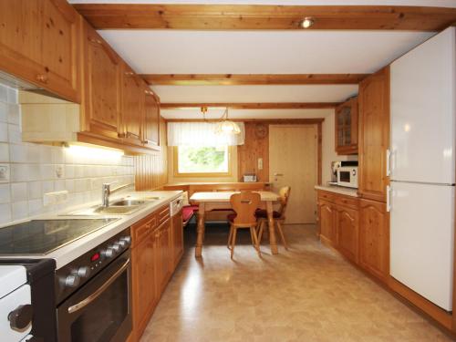 a kitchen with wooden cabinets and a table with a dining room at Holiday Home Josefine by Interhome in Jetzmund