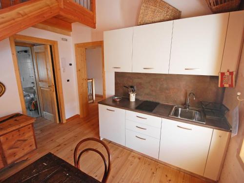 una cocina con armarios blancos y fregadero en Apartment Albergo Diffuso - Cjasa Ustin-3 by Interhome, en Barcis