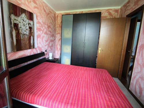 a bedroom with a bed with a pink blanket at Apartment Blue Lagoon by Interhome in  Monvalle 
