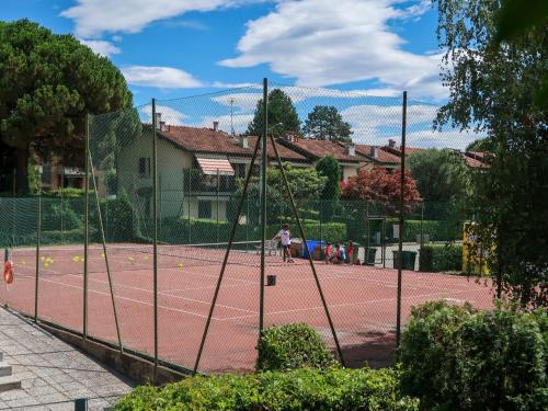 a person playing tennis on a tennis court at Apartment Blue Lagoon by Interhome in  Monvalle 