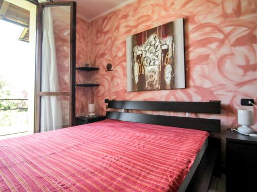 a bedroom with a red bed and a mirror at Apartment Blue Lagoon by Interhome in  Monvalle 