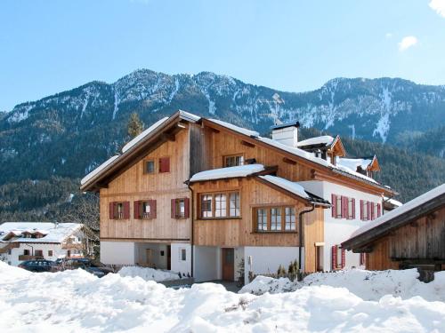 a house in the snow with mountains in the background at Holiday Home Mantel by Interhome in Mazzin