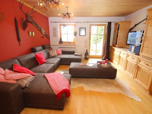 uma sala de estar com um sofá castanho e paredes vermelhas em Chalet Königsleiten 2 by Interhome em Königsleiten