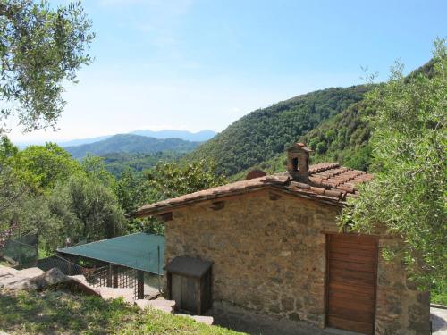 ein altes Steingebäude mit einem Berg im Hintergrund in der Unterkunft Holiday Home Castagneto by Interhome in Loppeglia