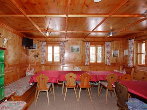 ein Esszimmer mit einem roten Tisch und Stühlen in der Unterkunft Holiday Home Tux Holiday Home by Interhome in Tux