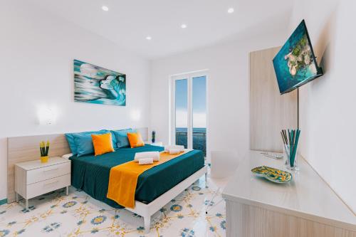 a bedroom with a bed and a desk in it at Villa Eris Amalfi Coast in Conca dei Marini