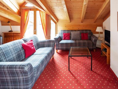 a living room with two couches and a table at Apartment Chalet Abendrot-23 by Interhome in Grindelwald
