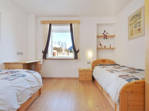 a bedroom with two beds and a window at Apartment Fabio Deluca by Interhome in Vigo di Fassa