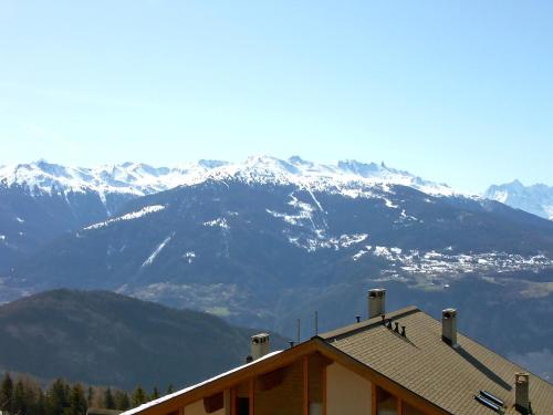 a house with a mountain range in the background at Chalet Clarine by Interhome in Anzère