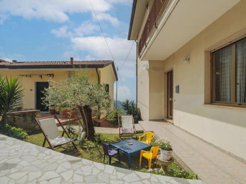 Un patio con una mesa y sillas frente a una casa. en Apartment Del Freo by Interhome, en Montignoso