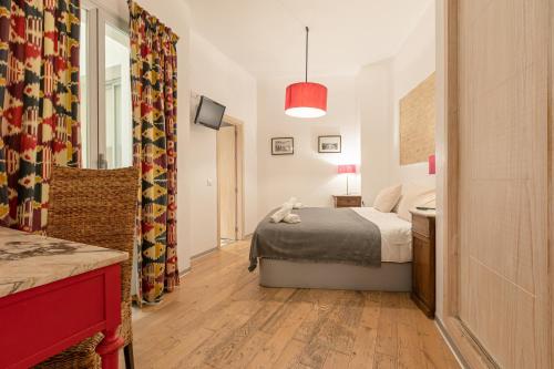 a small bedroom with a bed and a mirror at Hércules XCI Apartments in Seville