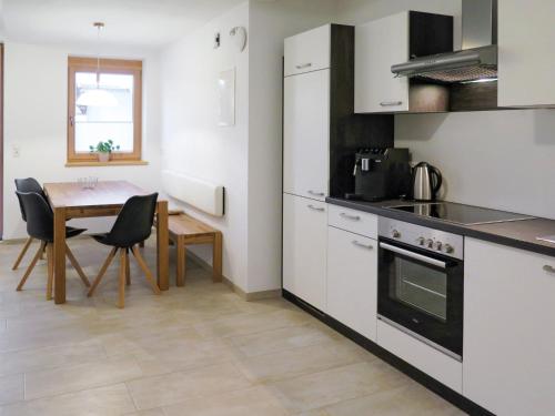 een keuken met een tafel en een eetkamer bij Apartment Luxner - KAB138 by Interhome in Kaltenbach